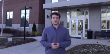 Reporter stands in front of a county municipal building