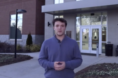 Reporter stands in front of a county municipal building