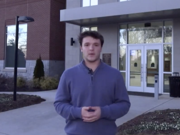 Reporter stands in front of a county municipal building