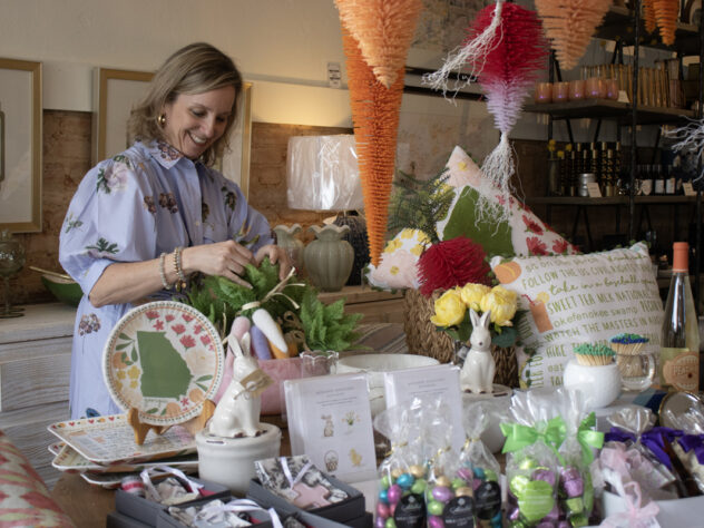 A woman stands next to a store display inside a store.