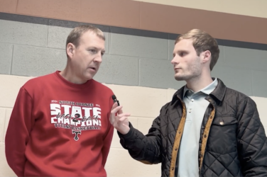 Sports reporter interviewing a coach in a gymnasium
