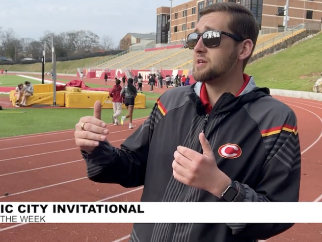 High school track coach standing on the track talking
