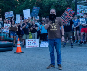 Georgia Representative Eric Gisler holding a megaphone and speaking to the protest
