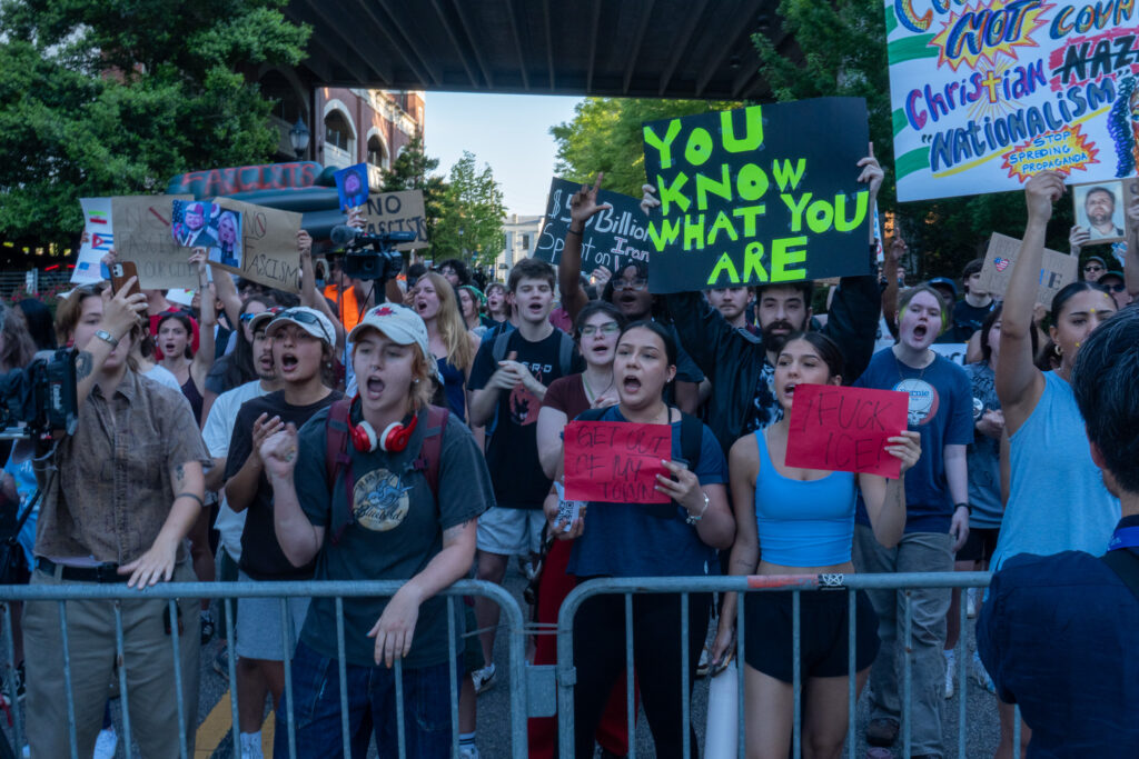 A line of protesters yell towards the Arena