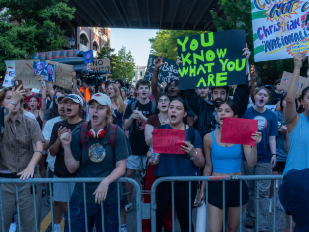 A line of protesters yell towards the Arena