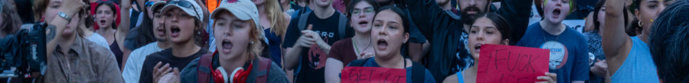 A line of protesters yell towards the Arena