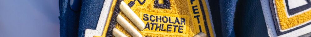 A high school letter jacketed decorated with numerous symbols, including stars.