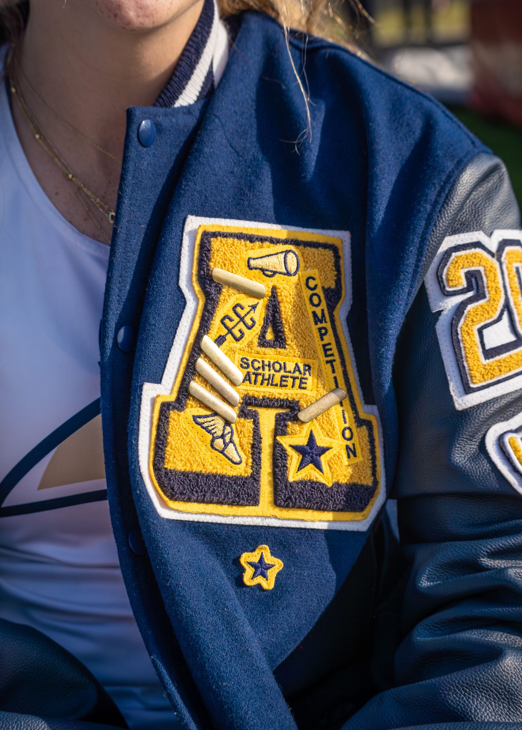 A high school letter jacketed decorated with numerous symbols, including stars.