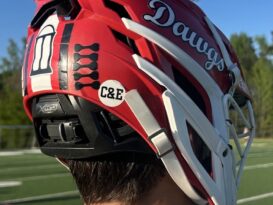 A lacrosse helmet with a sticker celebrating the coach's infant sons.