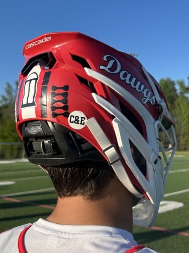 A lacrosse helmet with a sticker celebrating the coach's infant sons.