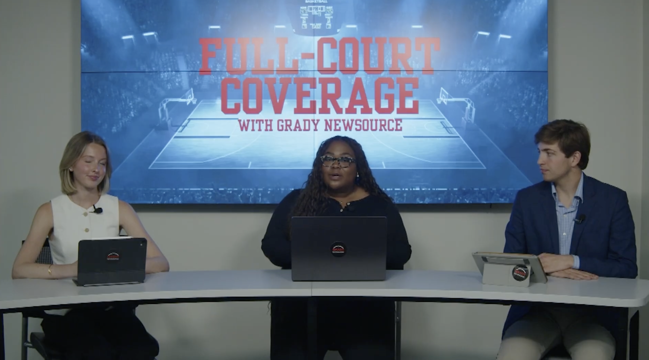 Three sports reporters sit at a desk and talk
