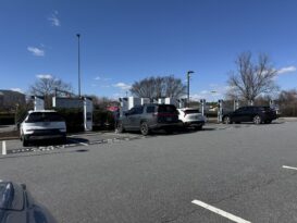 Electric cars being charged in a parking lot at a charging station