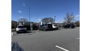 Electric cars being charged in a parking lot at a charging station