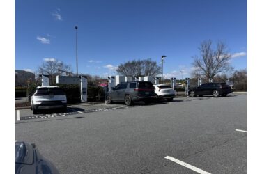 Electric cars being charged in a parking lot at a charging station