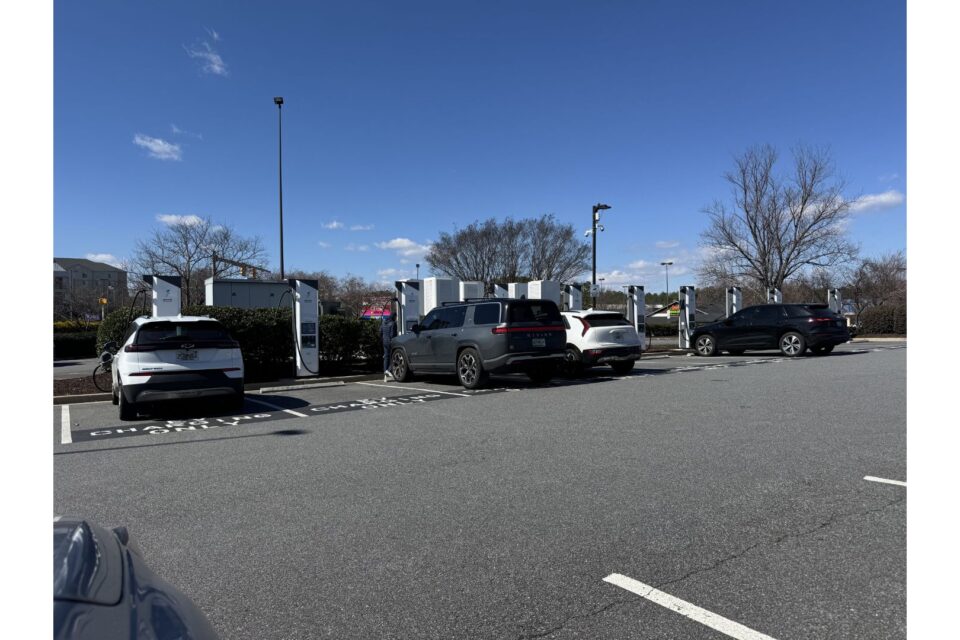 Electric cars being charged in a parking lot at a charging station