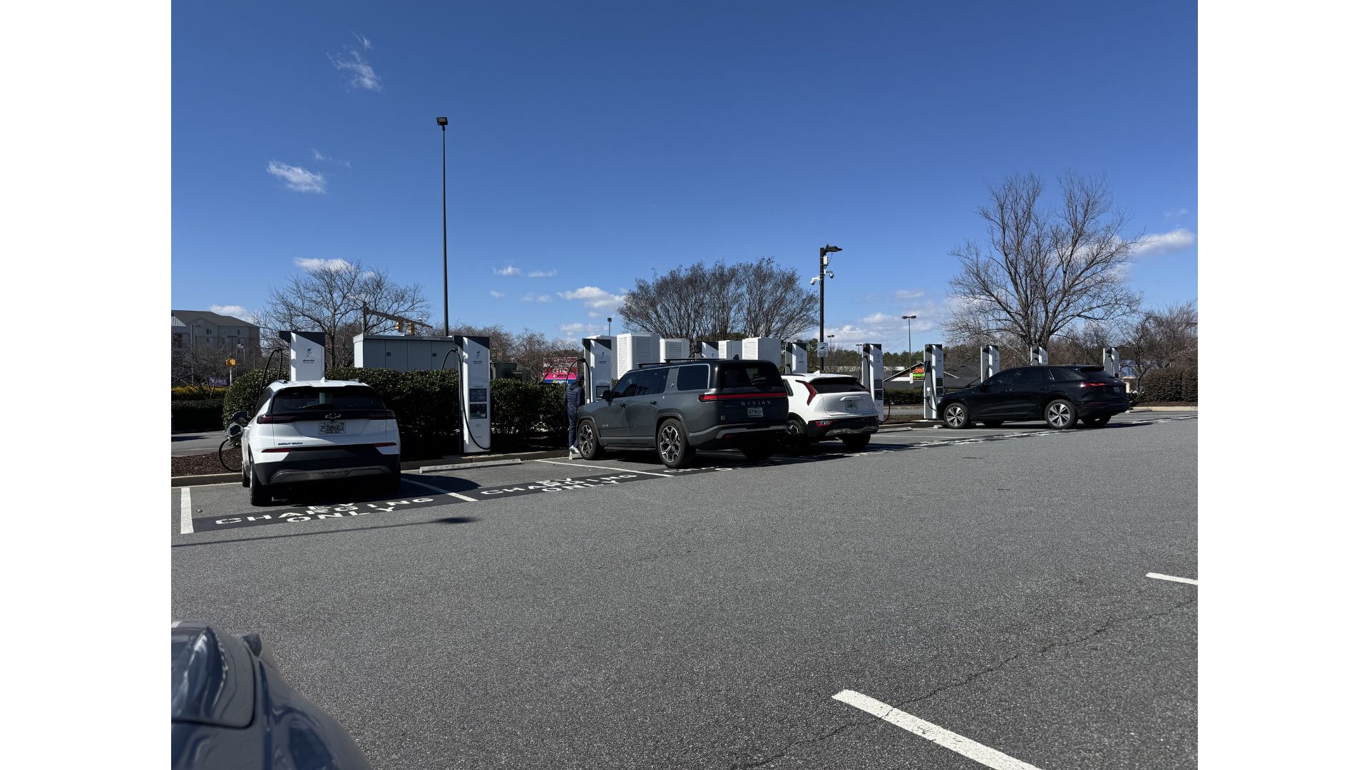 Electric cars being charged in a parking lot at a charging station