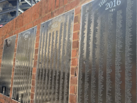 Senior Signature plaques displaying hundreds of engraved names hang on a brick wall at the Tate Student Center Plaza at the University of Georgia.