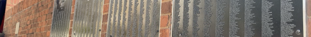 Senior Signature plaques displaying hundreds of engraved names hang on a brick wall at the Tate Student Center Plaza at the University of Georgia.