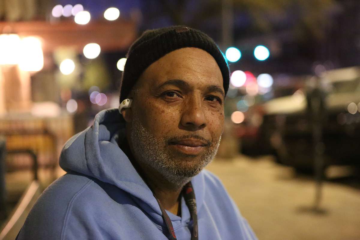 A portrait of a man sitting on a bench.