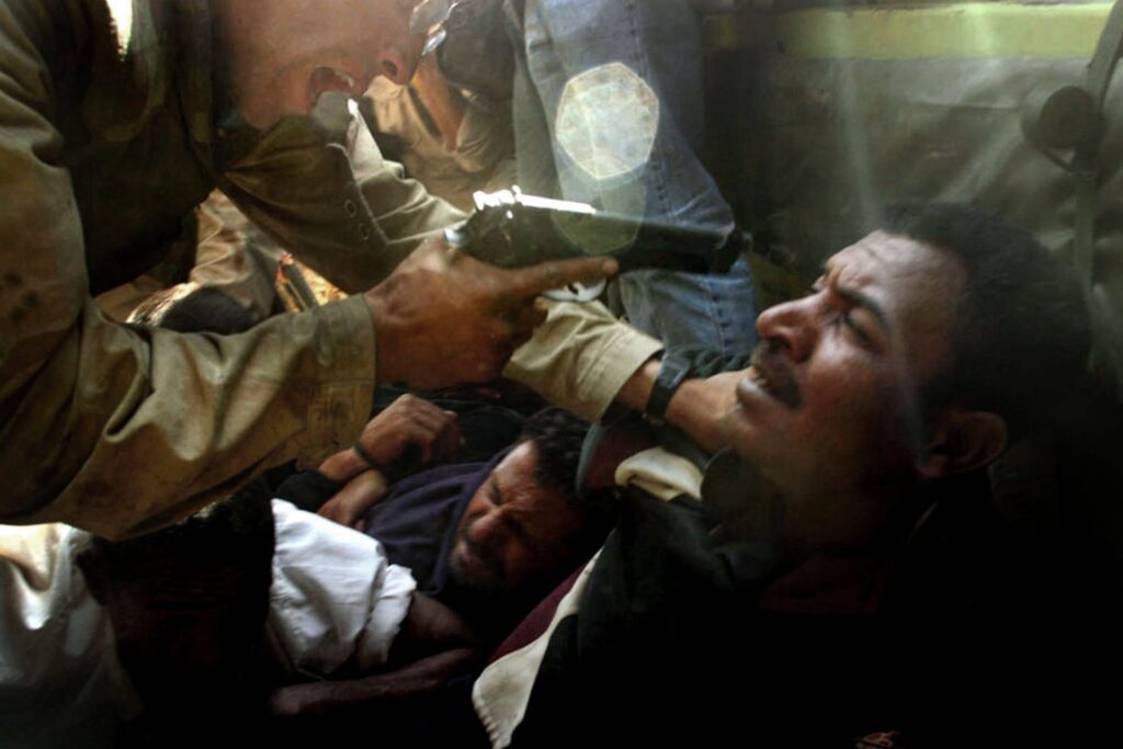 Iraq, 2003 a soldier points a gun at a man 