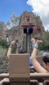 People raise their hands while on a roller coaster