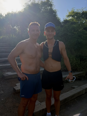 Man and younger man pose together on the steps of a mountain climb
