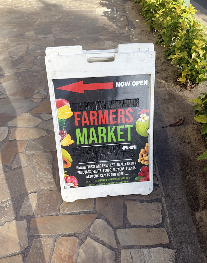 Farmers market sign set up on a cobblestone street