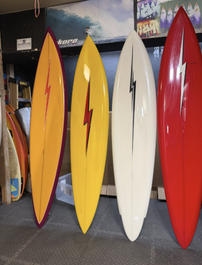 surfboards lined up at a shop