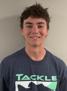 A male college student smiles at the camera