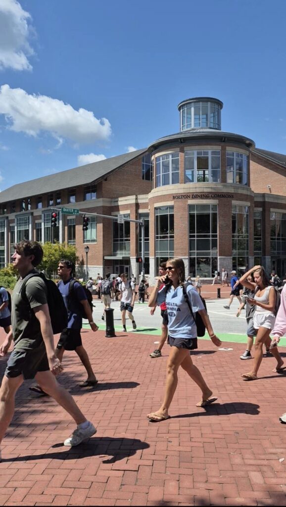 Students walk across the street on a college campus