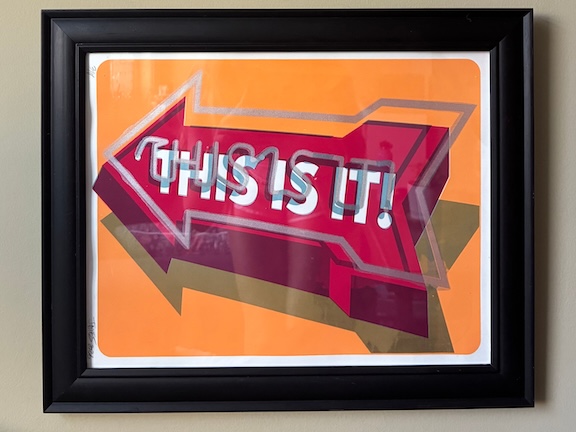 Print of light up LED sign that says THIS IS IT! 