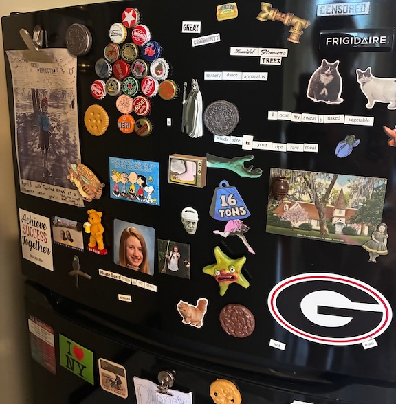 Fridge covered in various magnets and photos. 