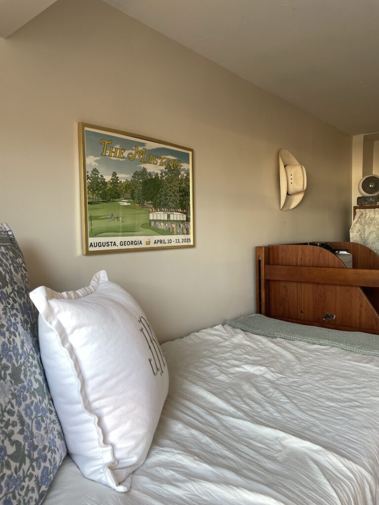 A framed poster from the Masters and a cowboy hat hang above Julia Randall's bed.