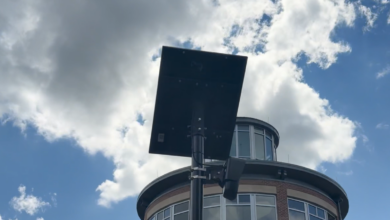A flock safety camera against the sky with clouds