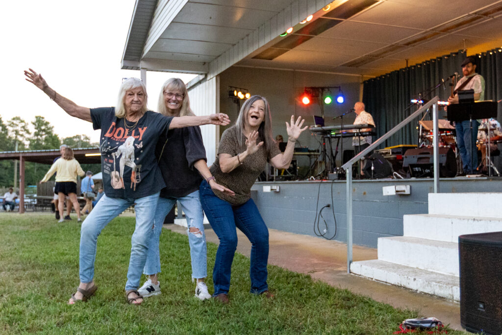 three women pose in front of a fair game