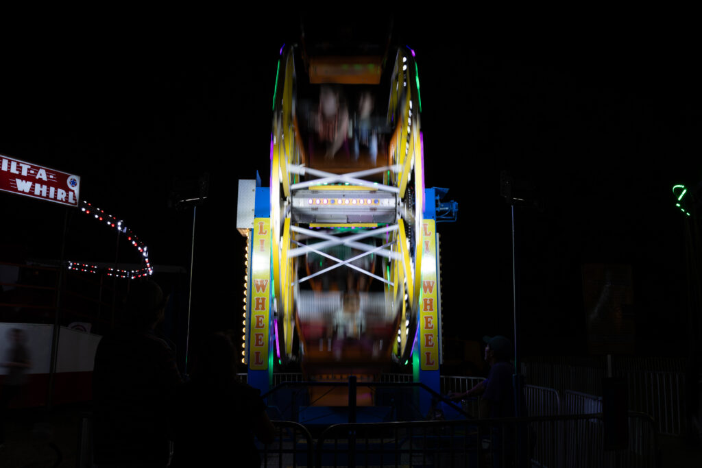lights shine at night on a fair ride