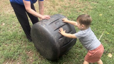 Mother and son turning composting barrel
