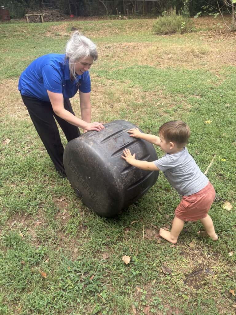Mother and son turning composting barrel