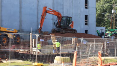 Construction workers and vehicles at the site of the North Downtown Athens redevelopment.