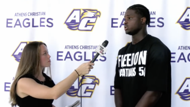 A reporter holds a microphone as an athlete answers a question